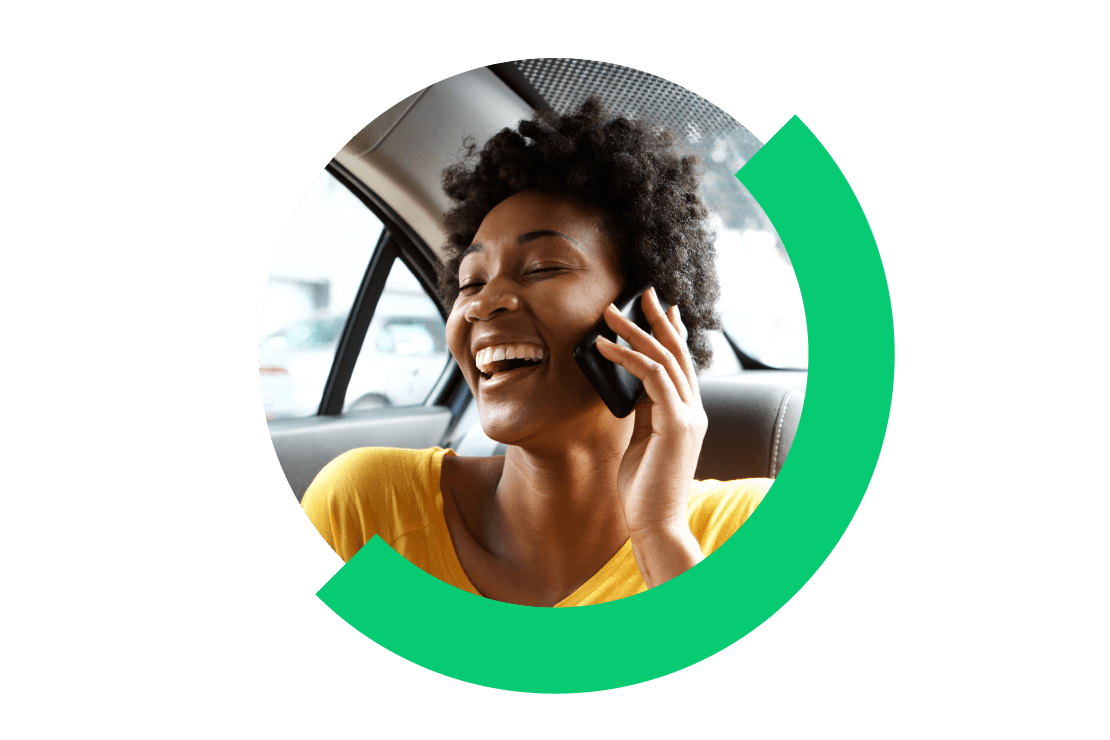 Passenger in a vehicle talking on phone, smiling, and laughing.